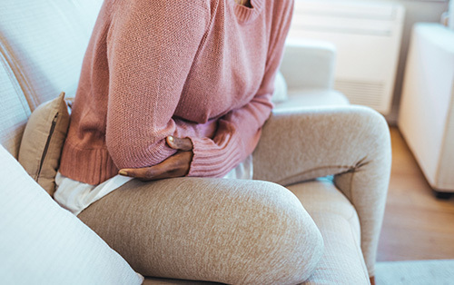 Cropped shot of an young woman suffering from period pains at home